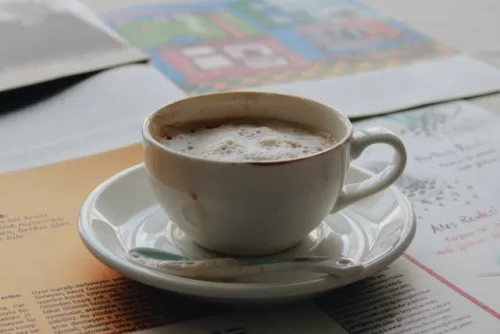 Comparison of a foamy cappuccino and a milky latte in ceramic mugs.